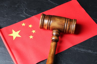 Photo of Judge's gavel and flag of China on black table, above view