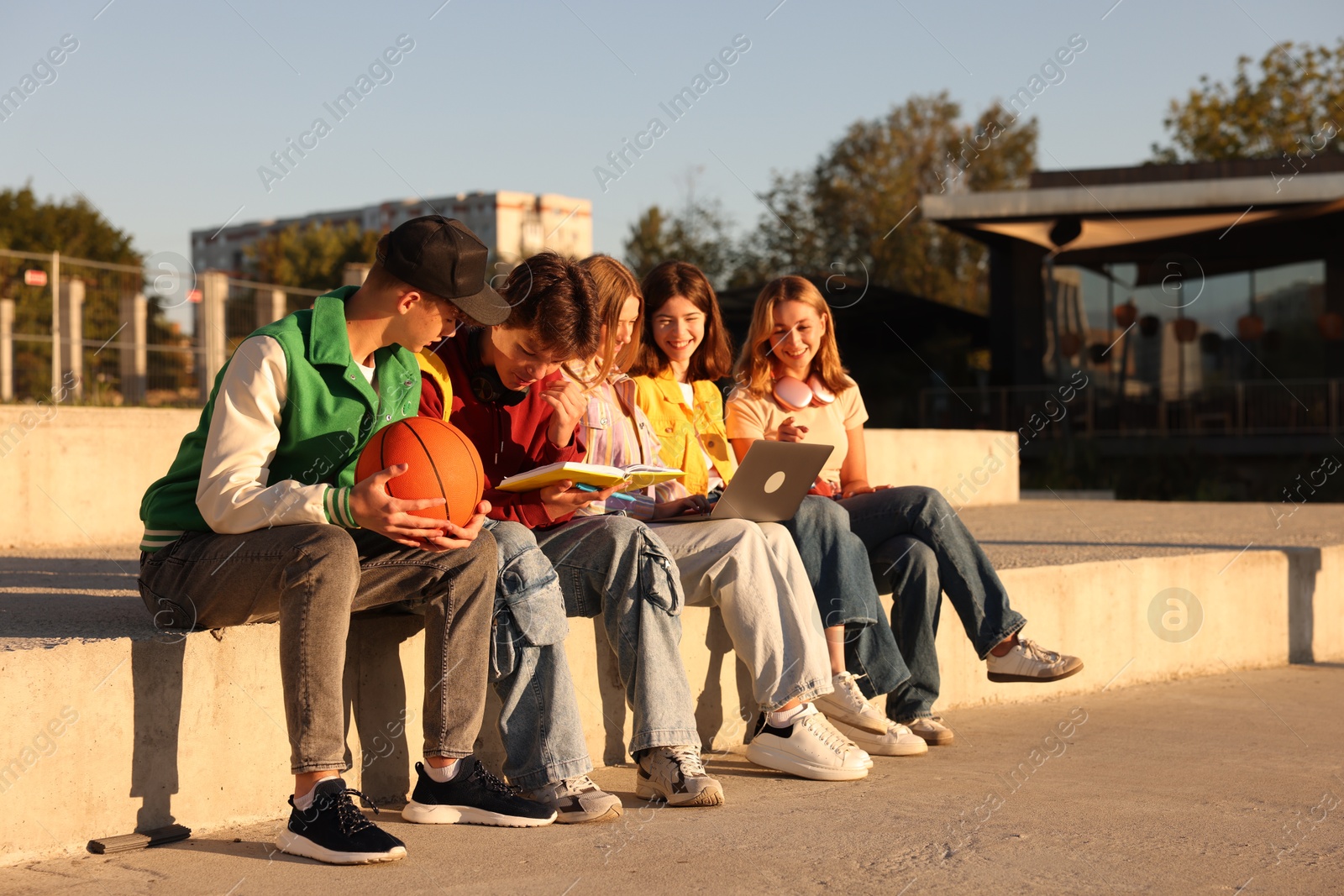 Photo of Group of teenagers doing homework together outdoors