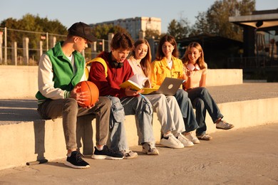 Photo of Group of teenagers doing homework together outdoors