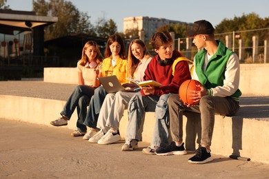 Photo of Group of teenagers doing homework together outdoors