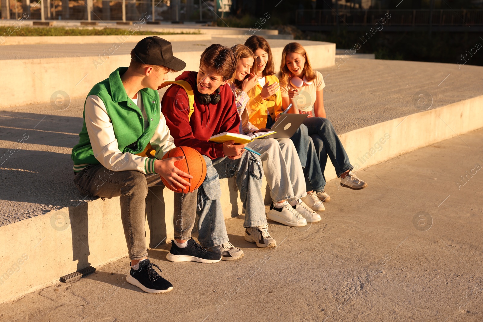 Photo of Group of teenagers doing homework together outdoors