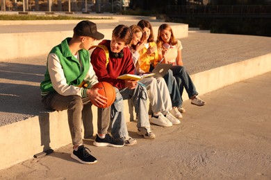 Photo of Group of teenagers doing homework together outdoors