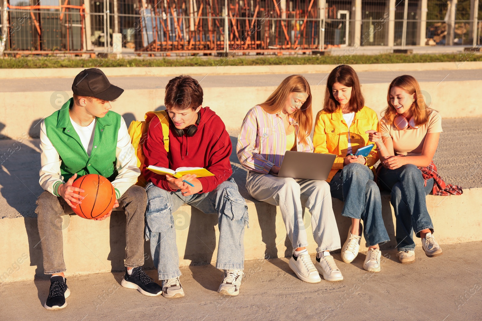 Photo of Group of teenagers doing homework together outdoors