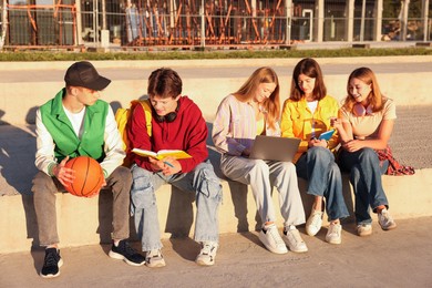 Photo of Group of teenagers doing homework together outdoors