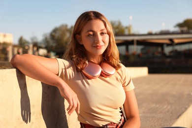 Photo of Teenage girl with headphones outdoors on sunny day