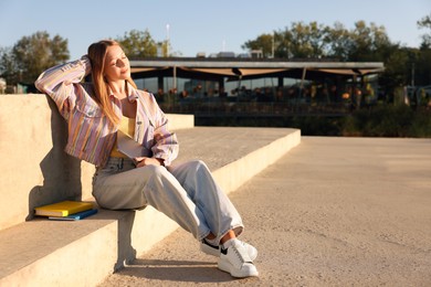 Photo of Teenage girl with laptop outdoors on sunny day, space for text