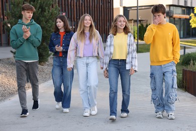Photo of Group of teenagers walking on city street