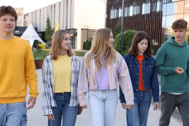 Photo of Group of teenagers walking on city street