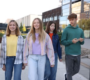 Photo of Group of teenagers walking on city street