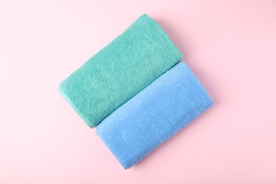 Photo of Bright terry towels on pink background, top view
