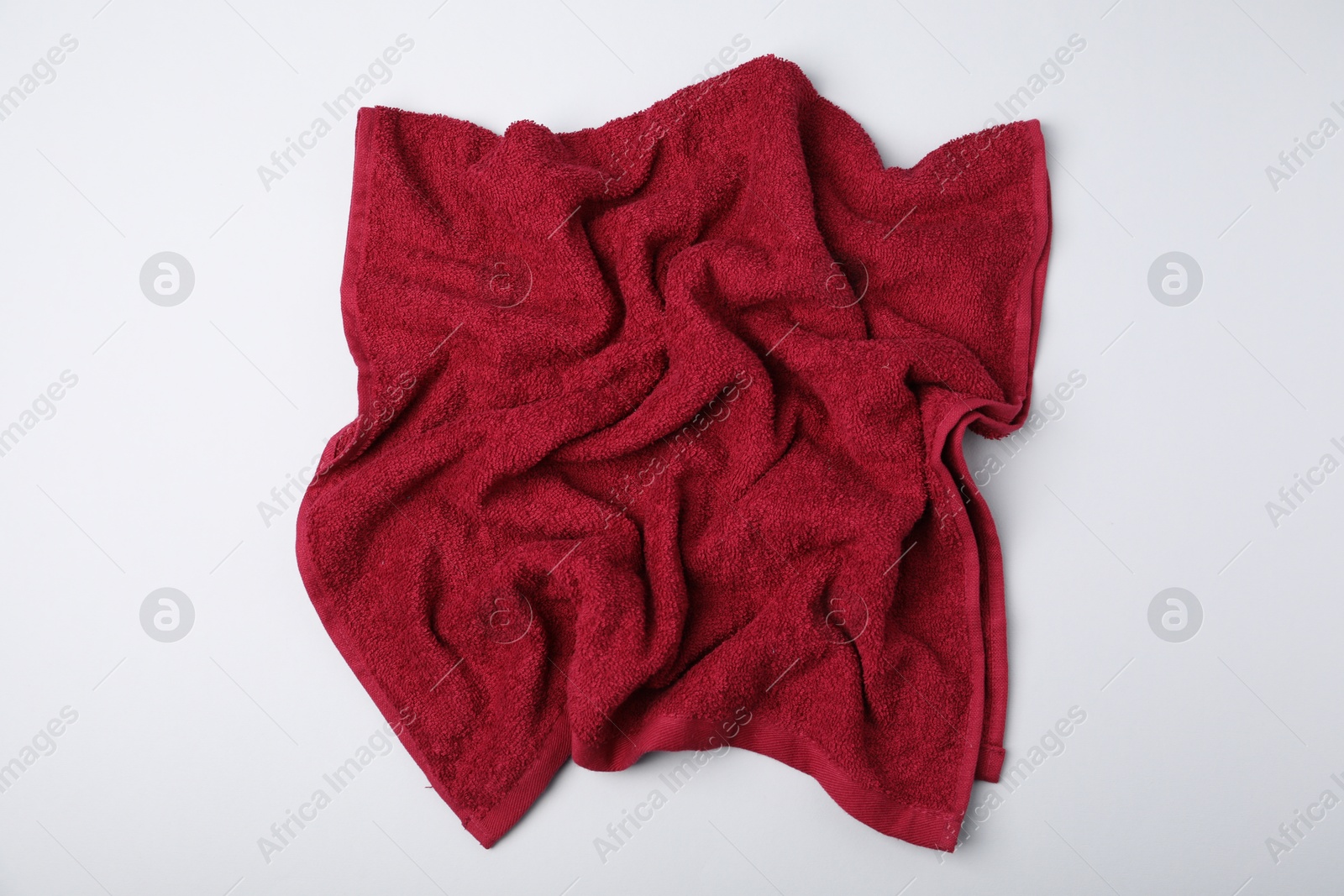 Photo of Red terry towel on light grey background, top view