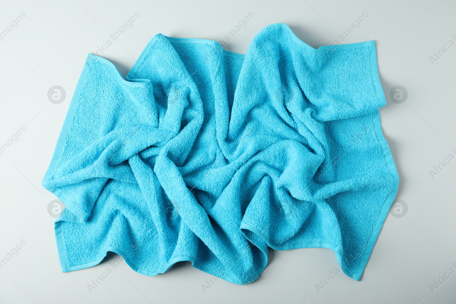 Photo of Light blue terry towel on grey background, top view