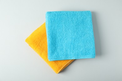 Photo of Bright terry towels on light grey background, top view