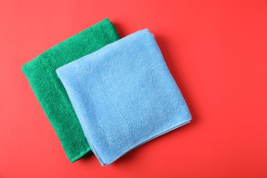 Photo of Bright terry towels on red background, top view. Space for text
