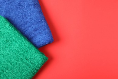 Photo of Bright terry towels on red background, top view. Space for text