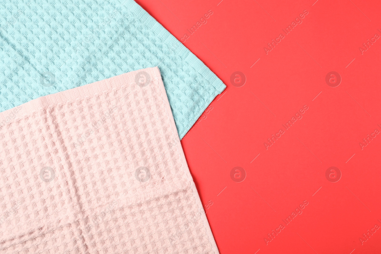 Photo of Clean waffle towels on red background, top view. Space for text