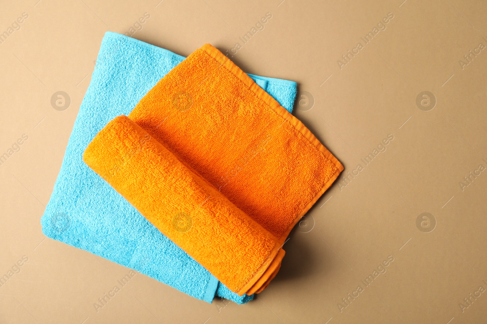Photo of Bright terry towels on beige background, top view. Space for text