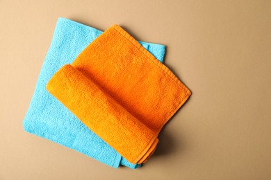 Photo of Bright terry towels on beige background, top view. Space for text