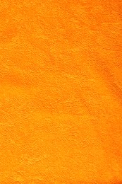 Photo of Orange terry towel as background, top view