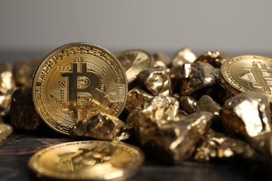 Photo of Bitcoins and gold nuggets on table, closeup