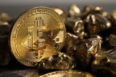 Photo of Bitcoin and gold nuggets on table, closeup