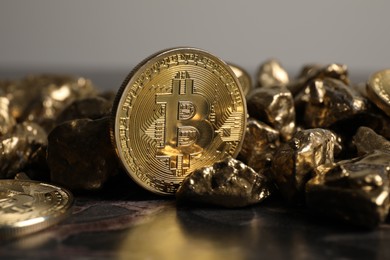 Photo of Bitcoins and gold nuggets on table, closeup