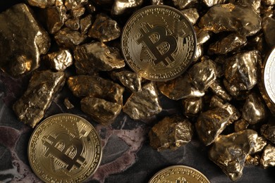 Photo of Bitcoins and gold nuggets on table, flat lay