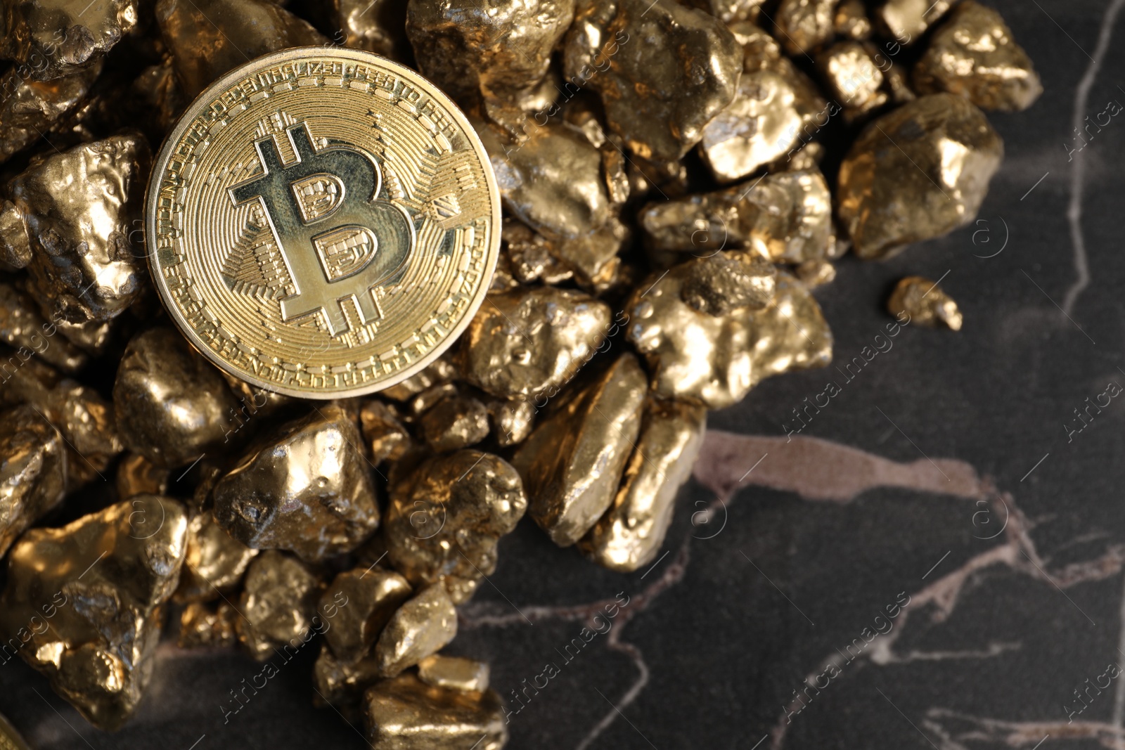 Photo of Bitcoin and gold nuggets on table, flat lay