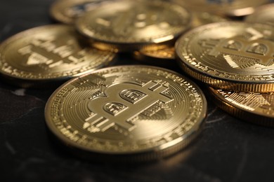 Photo of Cryptocurrency. Bitcoins on black table, closeup view