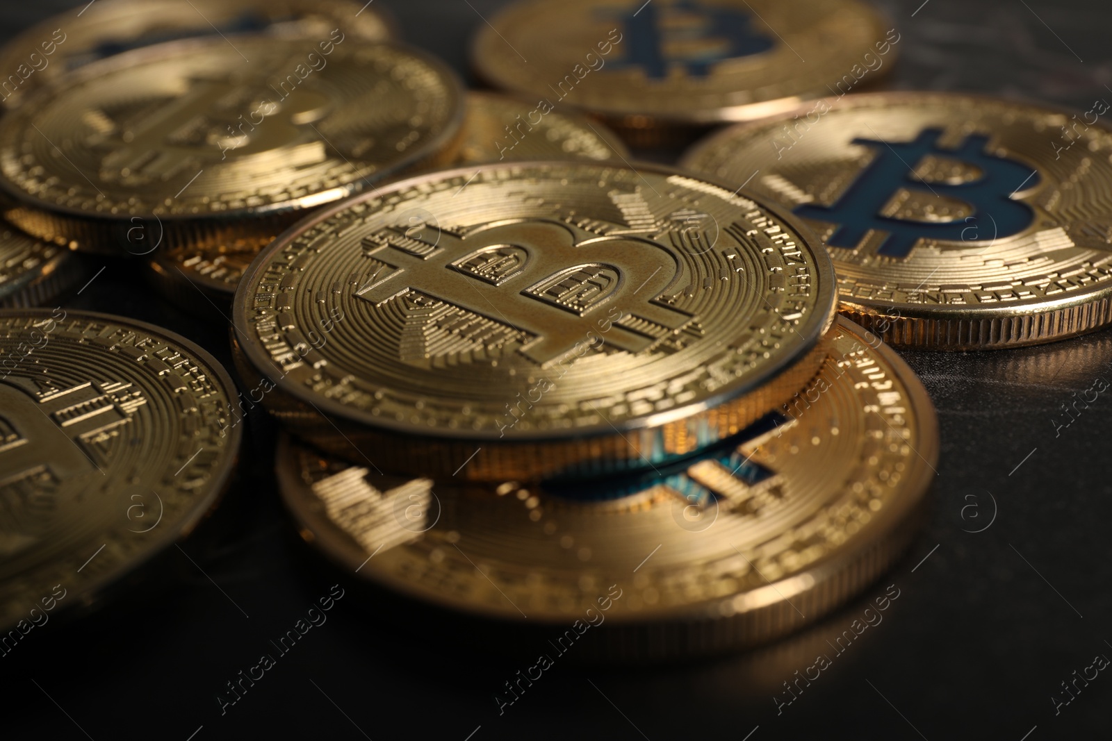 Photo of Cryptocurrency. Bitcoins on black table, closeup view