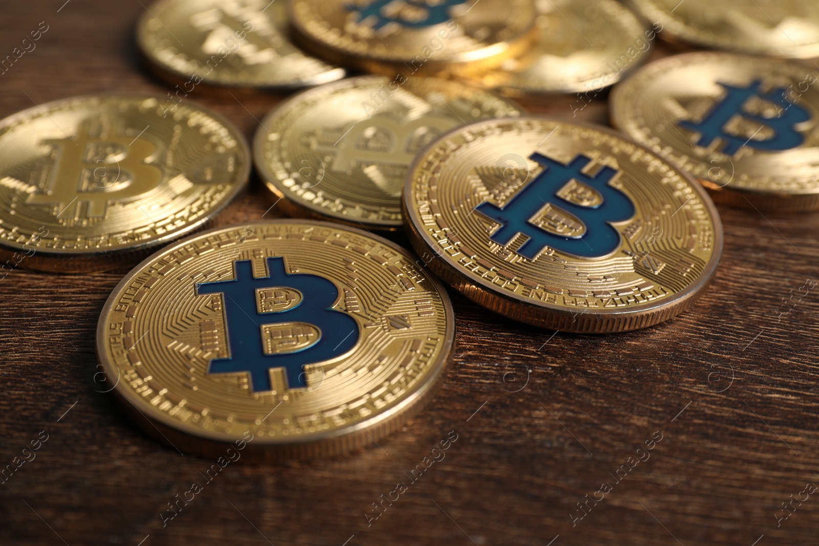 Photo of Cryptocurrency. Bitcoins on wooden table, closeup view