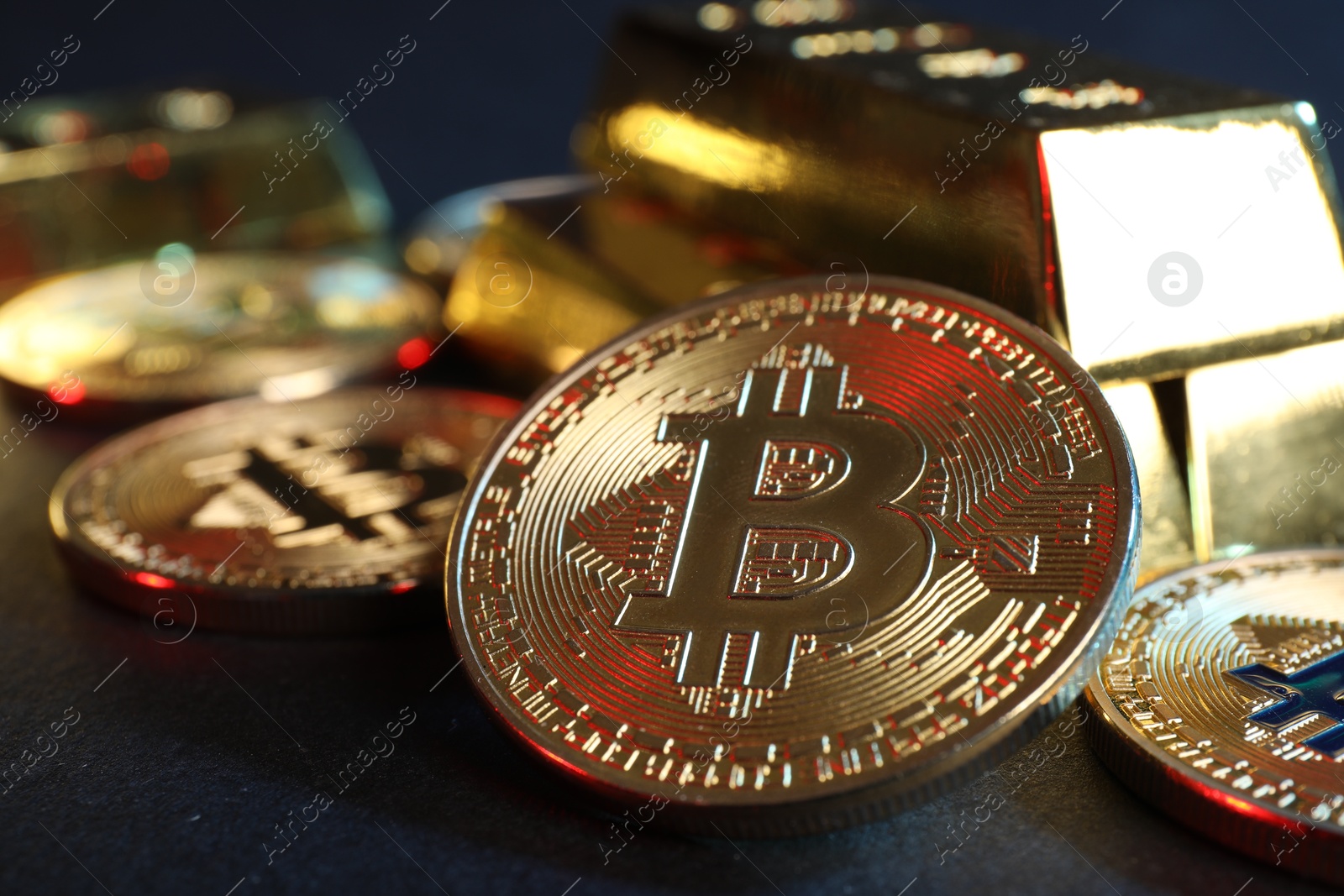 Photo of Bitcoins and gold bars on blue background, closeup