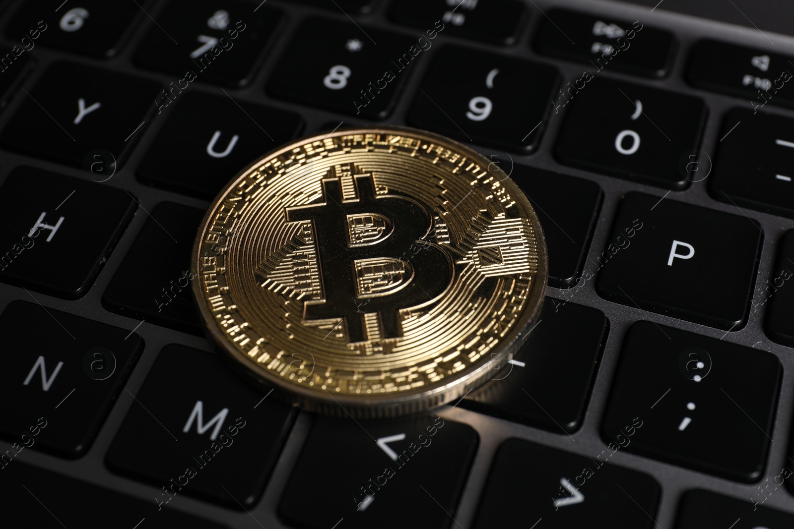 Photo of Cryptocurrency. Bitcoin on laptop keyboard, closeup view