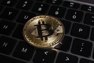Photo of Cryptocurrency. Bitcoin on laptop keyboard, closeup view