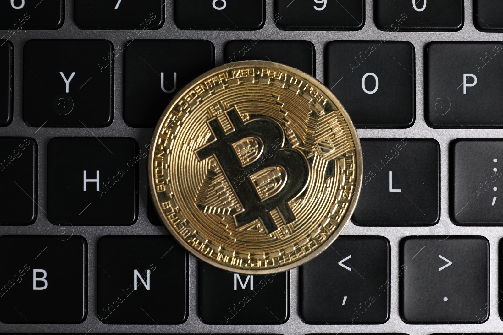 Photo of Cryptocurrency. Bitcoin on laptop keyboard, top view
