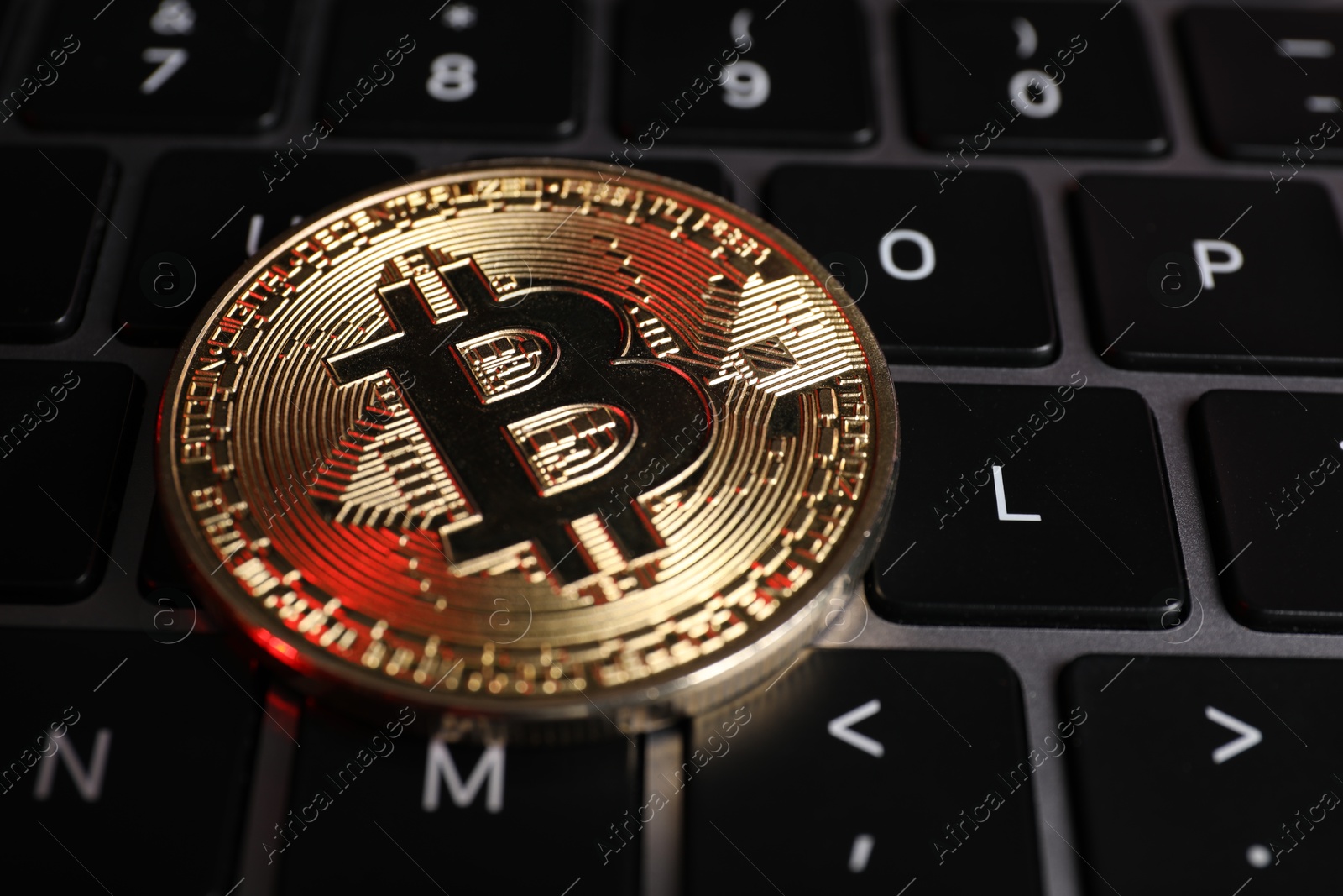 Photo of Cryptocurrency. Bitcoin on laptop keyboard, closeup view