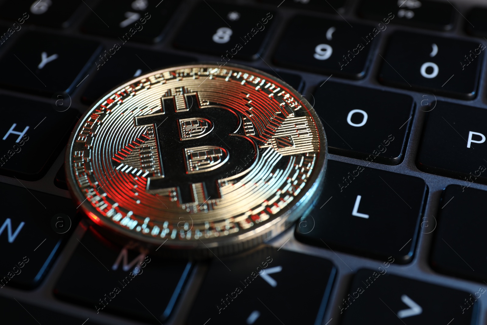 Photo of Cryptocurrency. Bitcoin on laptop keyboard, closeup view