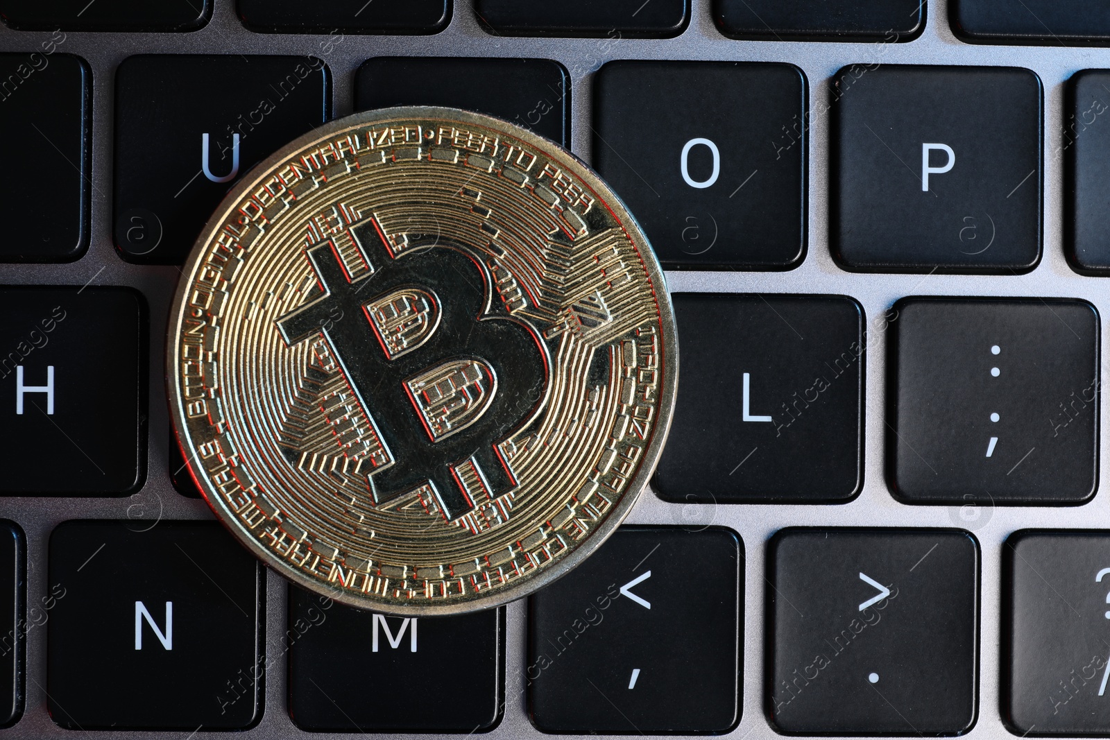 Photo of Cryptocurrency. Bitcoin on laptop keyboard, top view