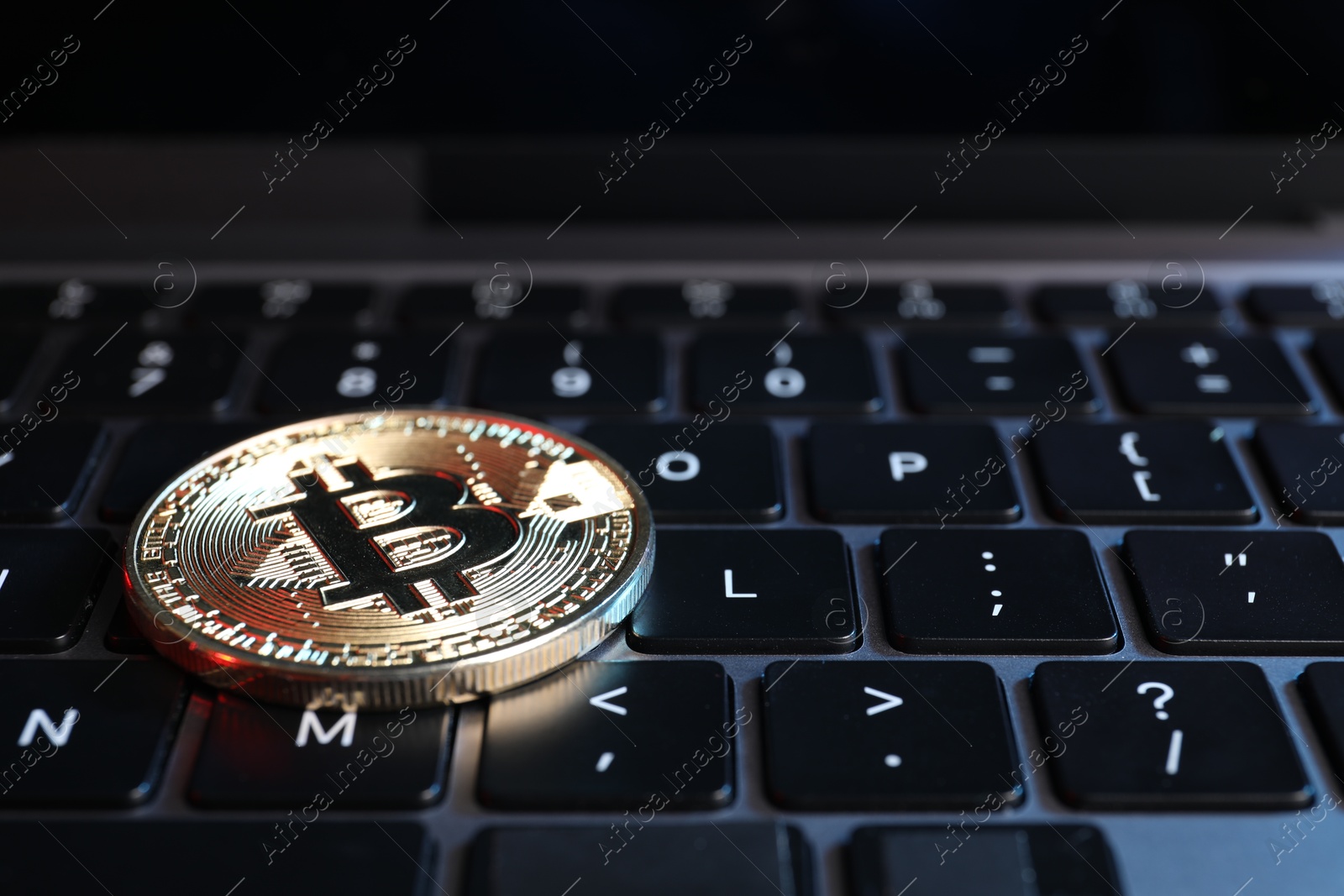 Photo of Cryptocurrency. Bitcoin on laptop keyboard, closeup view