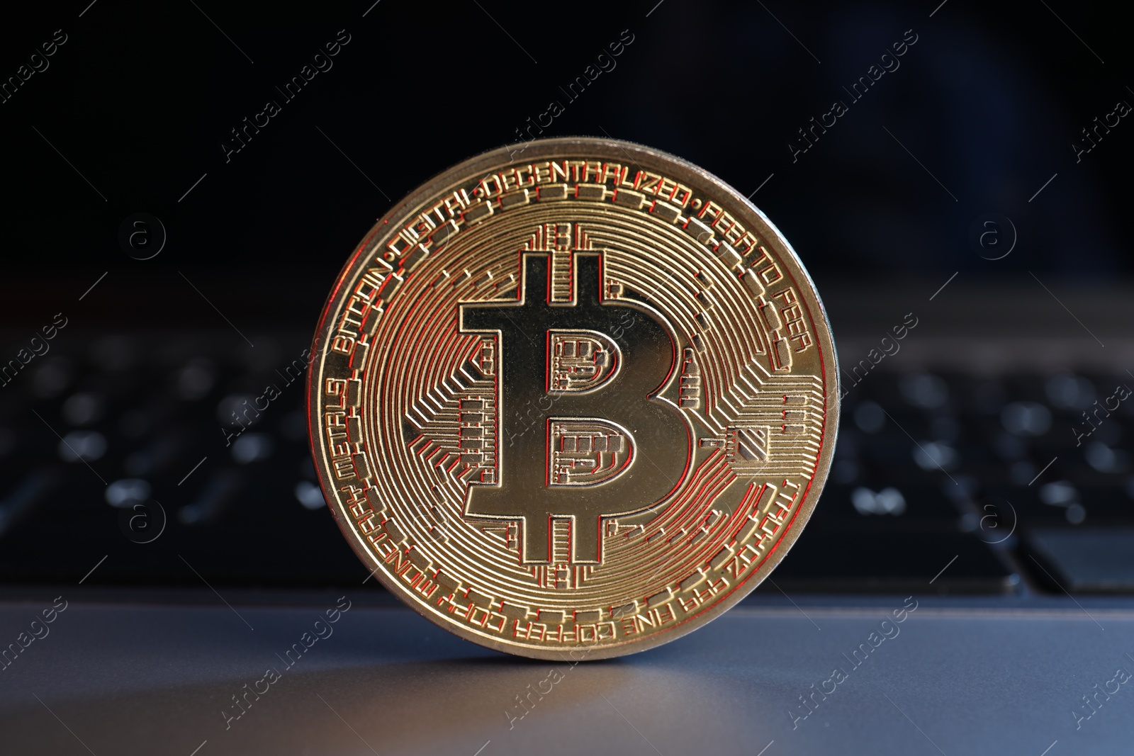 Photo of Cryptocurrency. Golden bitcoin on laptop, closeup view