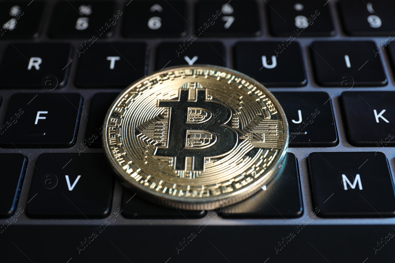 Photo of Cryptocurrency. Bitcoin on laptop keyboard, closeup view
