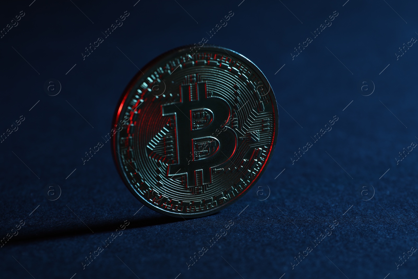 Photo of Cryptocurrency. Bitcoin on blue background, closeup view