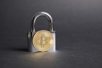 Photo of Bitcoin and padlock on grey background, closeup. Space for text
