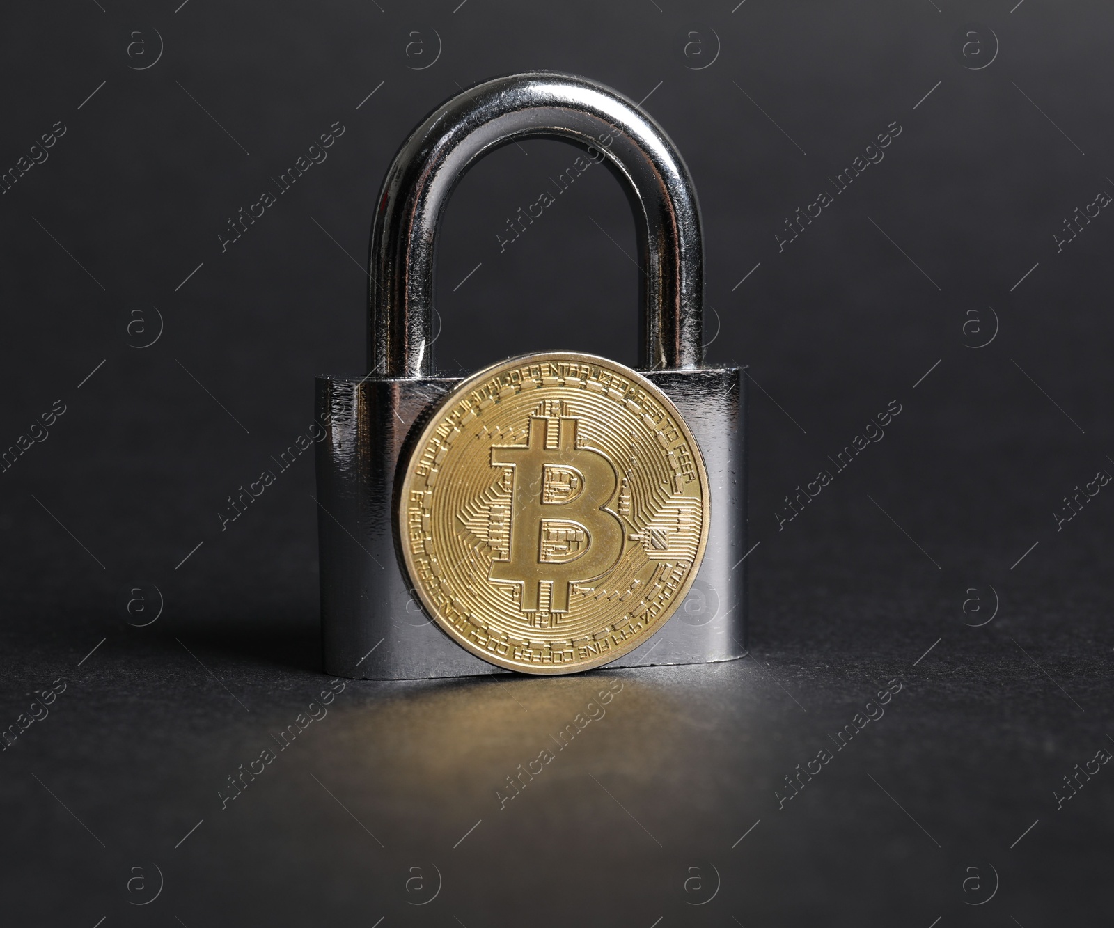 Photo of Bitcoin and padlock on grey background, closeup