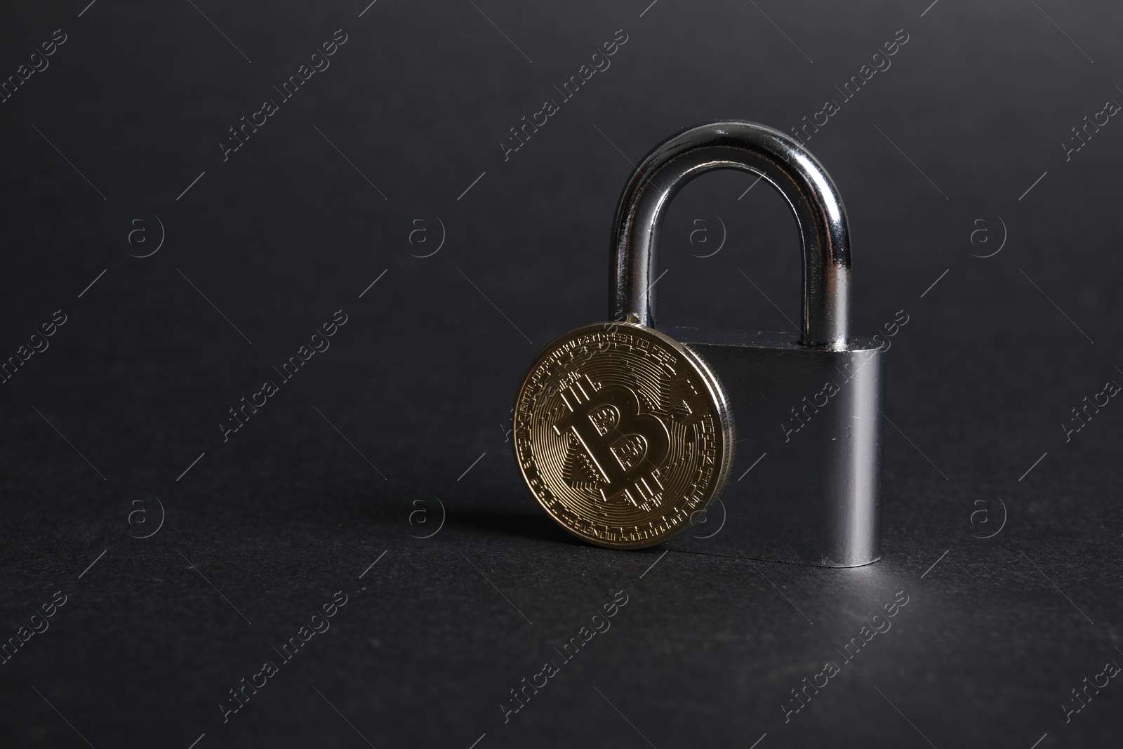 Photo of Bitcoin and padlock on grey background, closeup. Space for text