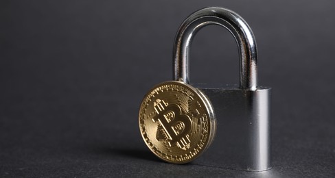 Photo of Bitcoin and padlock on grey background, closeup. Space for text