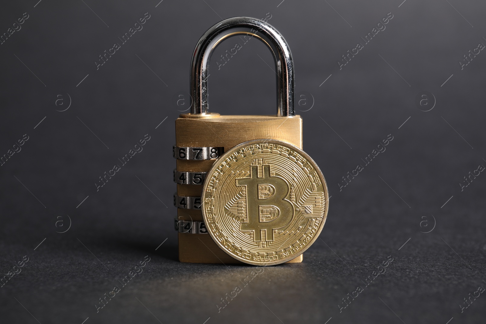 Photo of Bitcoin and padlock on grey background, closeup
