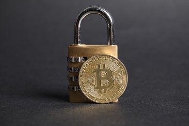 Photo of Bitcoin and padlock on grey background, closeup
