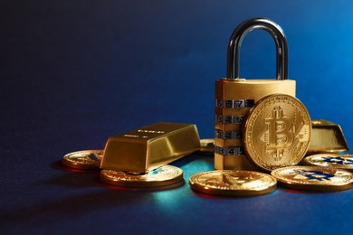 Photo of Bitcoins, padlock and gold bars on blue background, closeup. Space for text