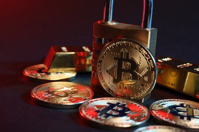 Photo of Bitcoins, padlock and gold bars on blue background, closeup